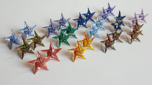 Colorful star-shaped origami earrings arranged in a row on a light background.