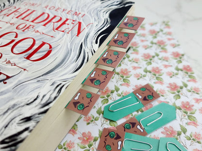 Children of Blood and Bone book with decorative paper clips on a floral background.